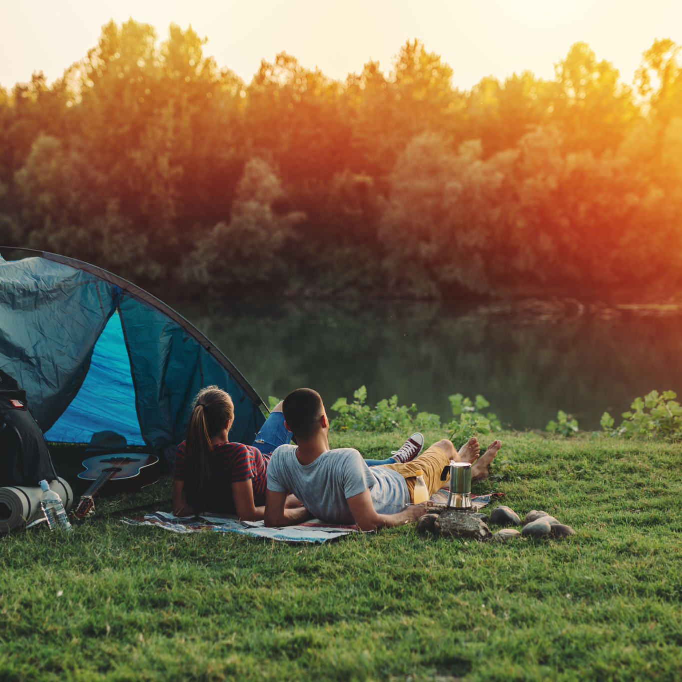 young couple relaxing by the river. camping outdoor